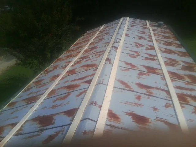 Rusted metal roof panels with new wood purlins before replacement — Storm Damage Roof Repair in Marine City by Roofing Brothers