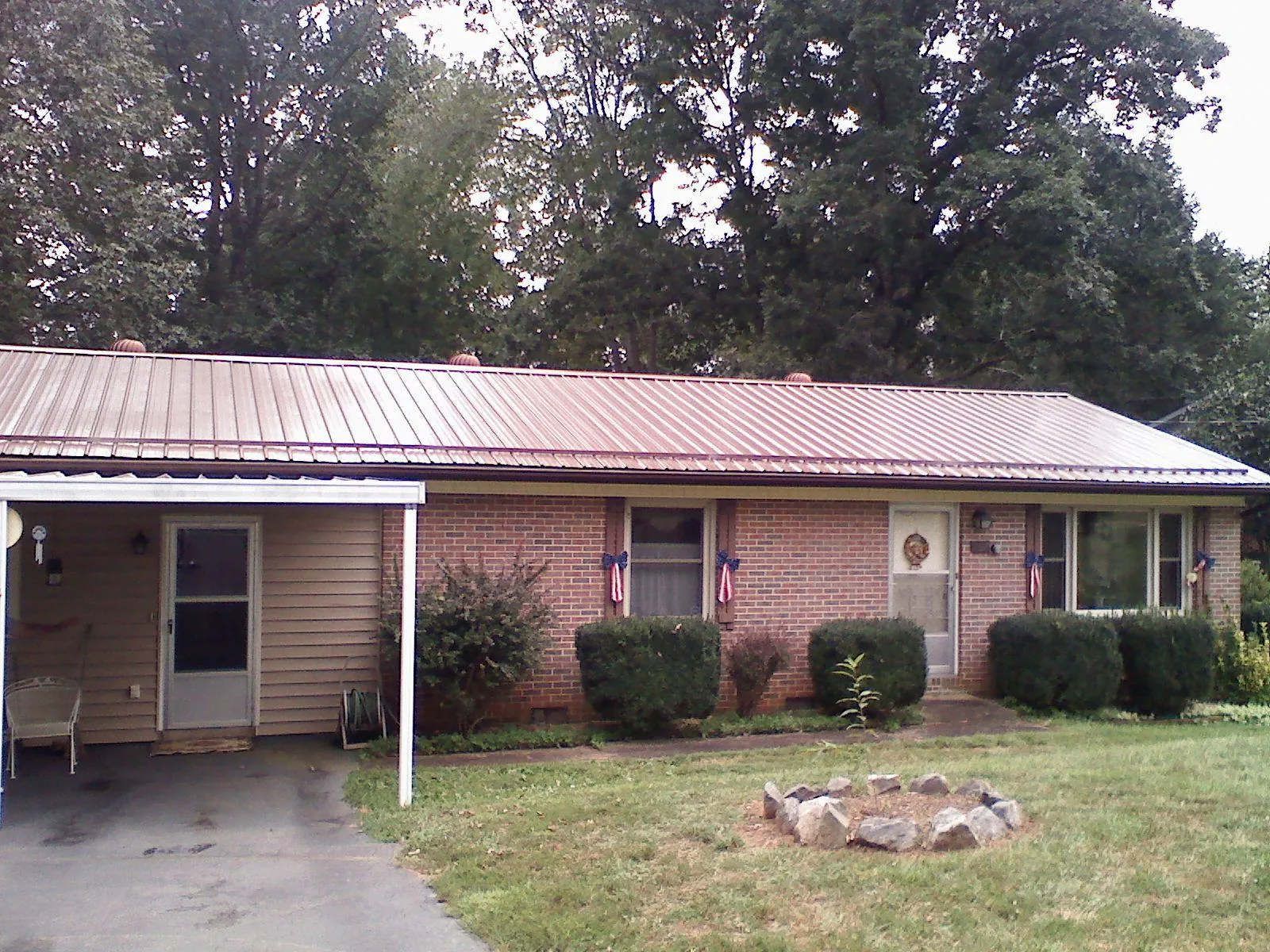 Bronze metal roof and carport on a brick ranch home — Roof Repair work by our crew in Marine City