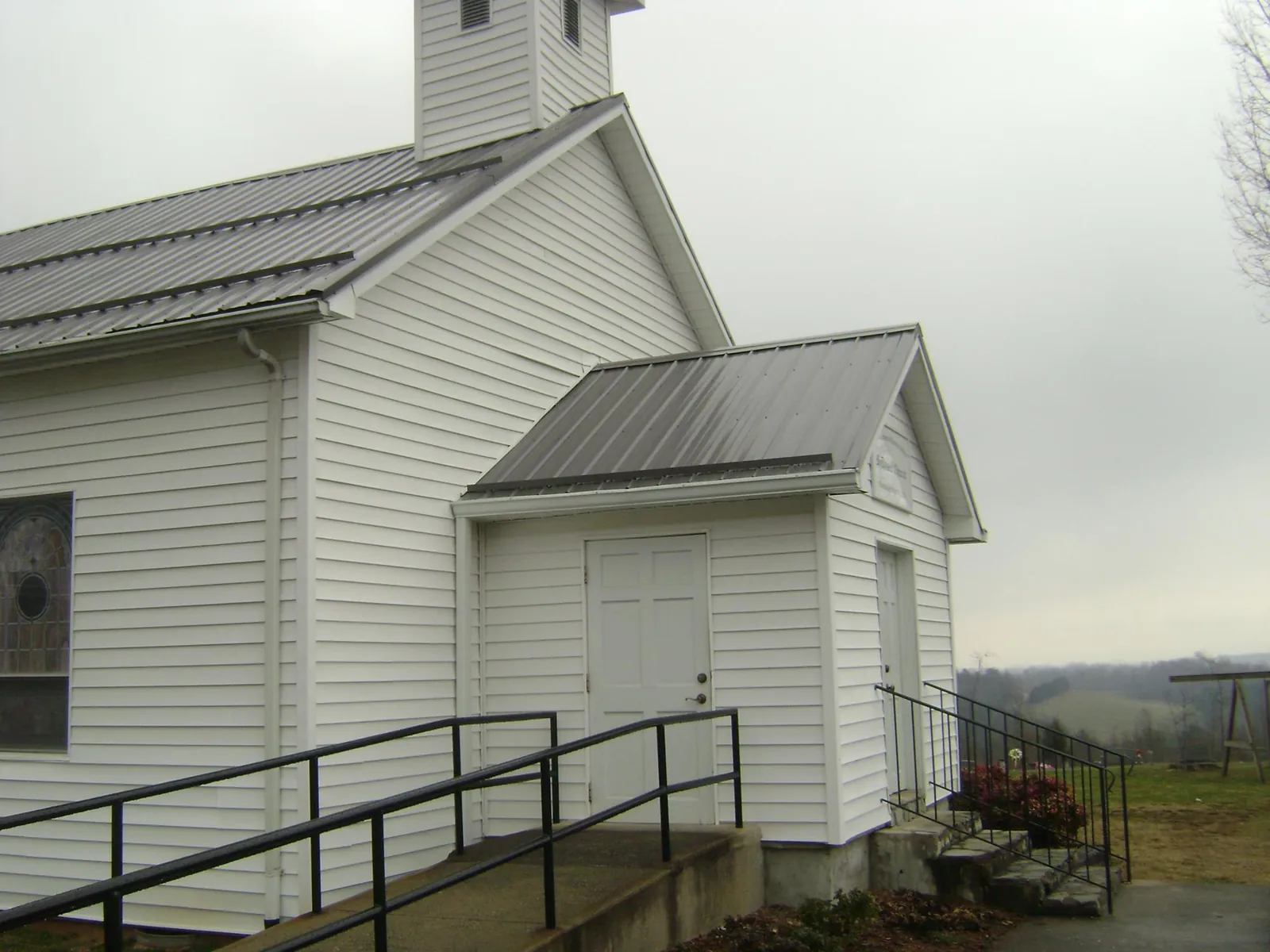 Gray metal roof on a white clapboard church with a steeple in Marine City