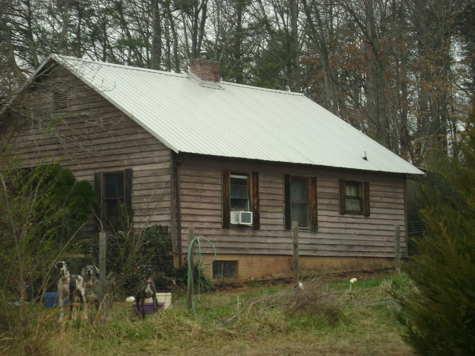 White metal roof on an old wood sided farmhouse, from a Metal Roof Installation job in Marine City